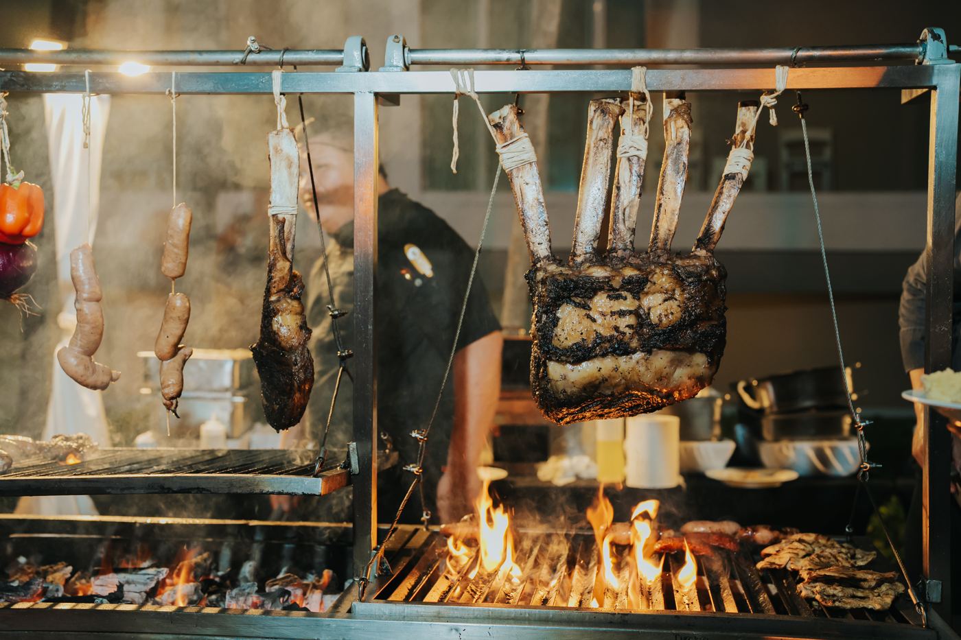 Open-fire grill station with meats roasting