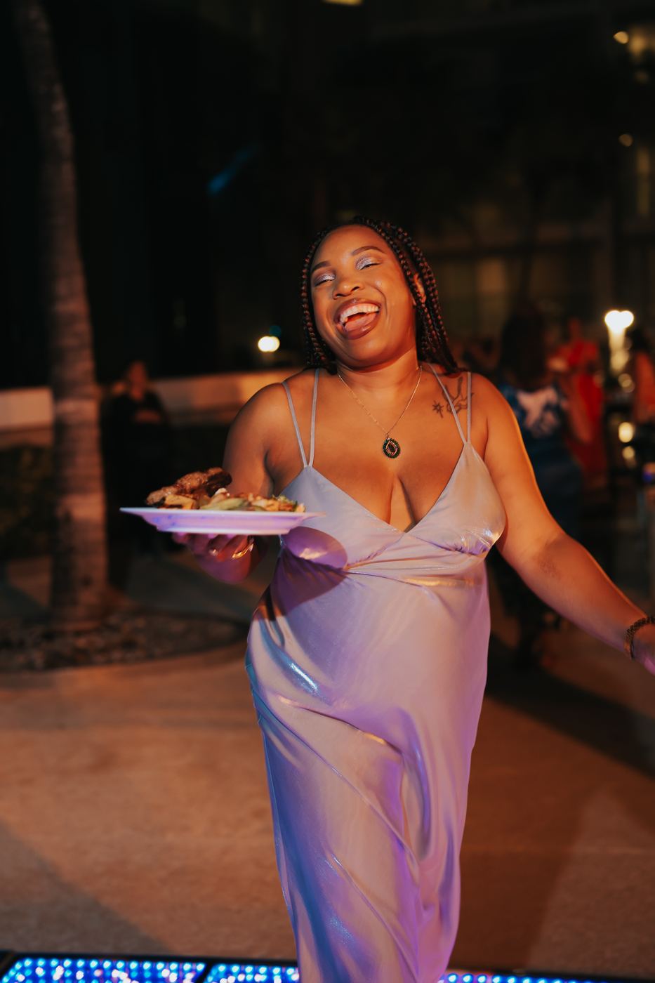 A wedding guest laughing with her dinner plate