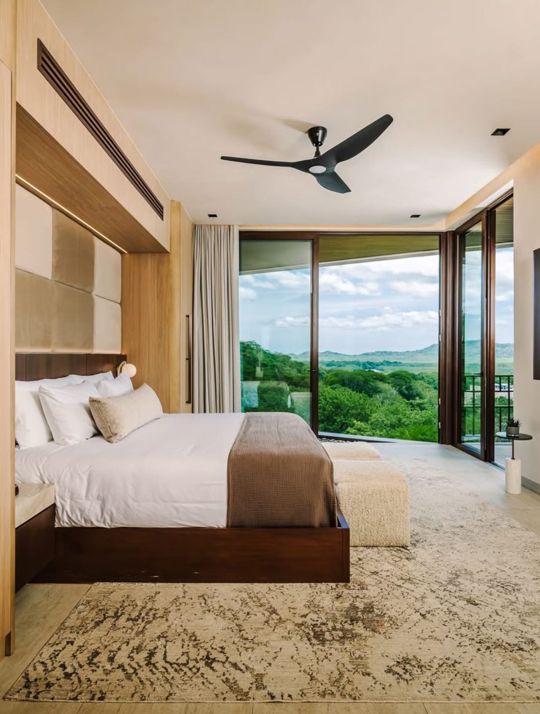 Bedroom with floor-to-ceiling windows and a jungle view