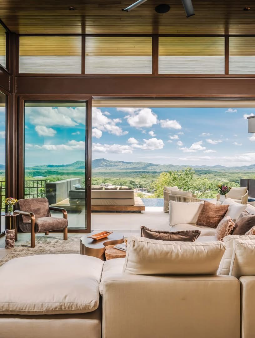 Open living room with walls of glass facing the mountains