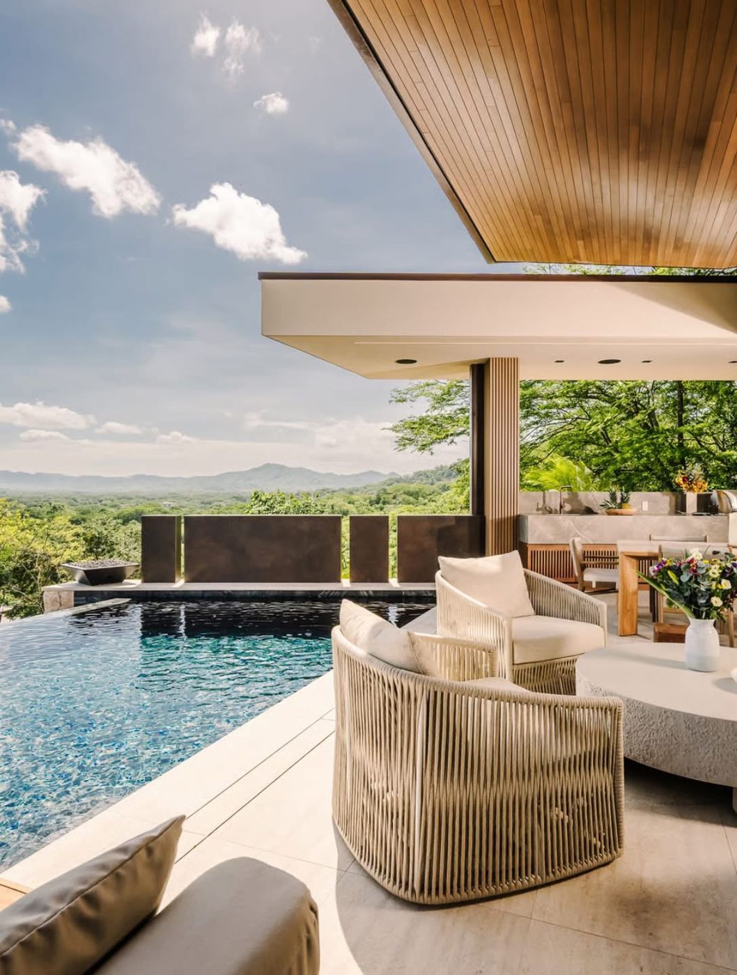 Lounge chairs beside an infinity pool overlooking the hills
